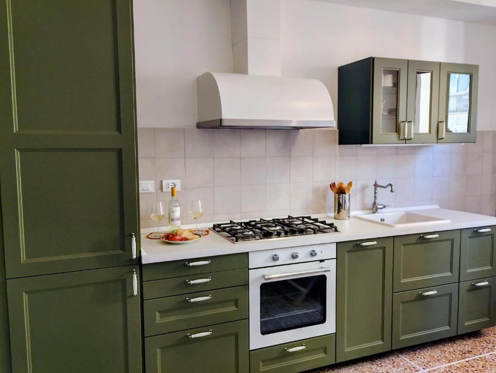 Cucina attrezzata con mobili verdi e balcone a Libertà Home Livorno