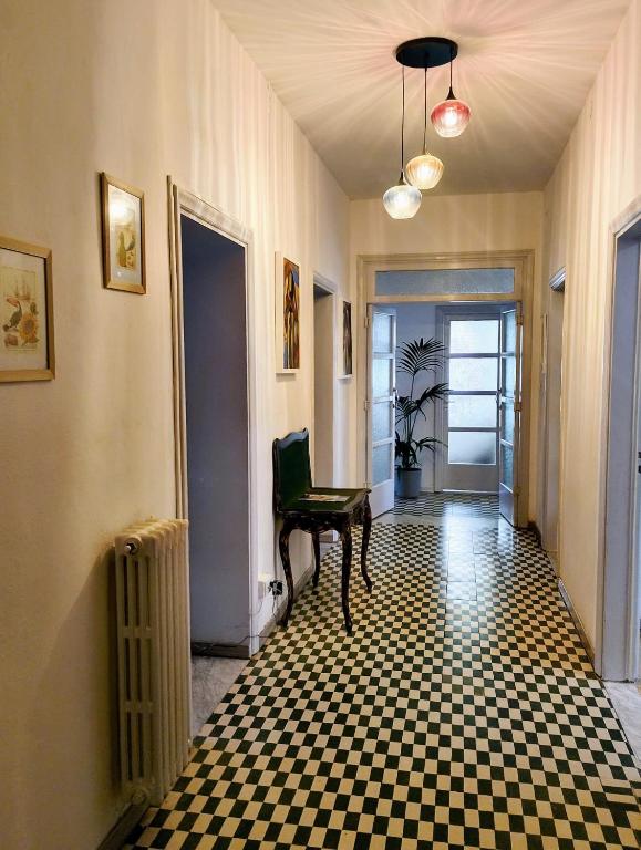 Corridoio con pavimento a scacchi e lampadario a Libertà Home
